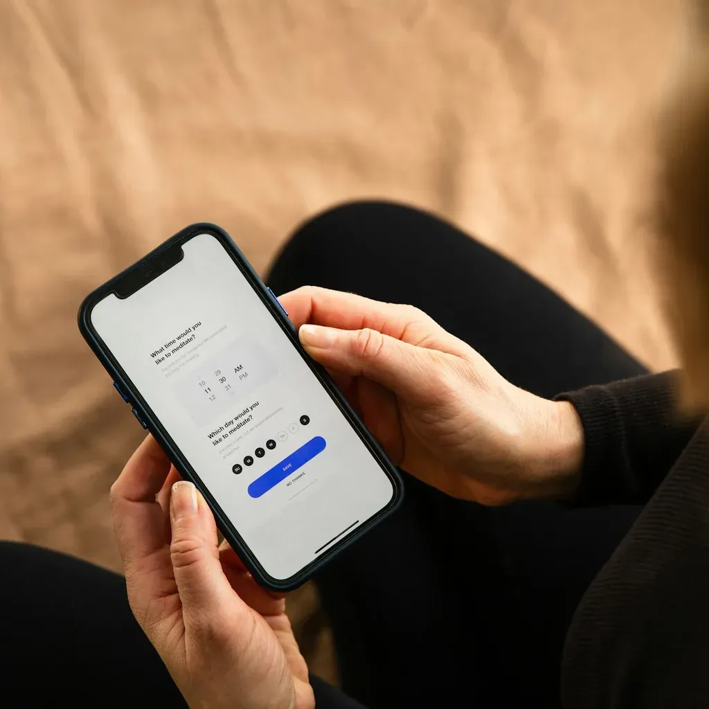 Hands holding a phone showing a short form with a blue submit button