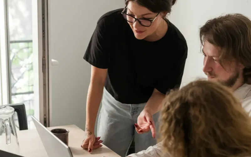 Three people reviewing a design together at a laptop